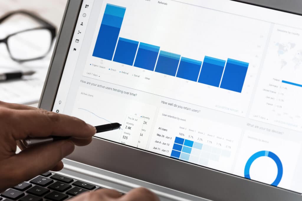 Osoba korzystająca z laptopa z wykresem na ekranie w agencji marketingowej.