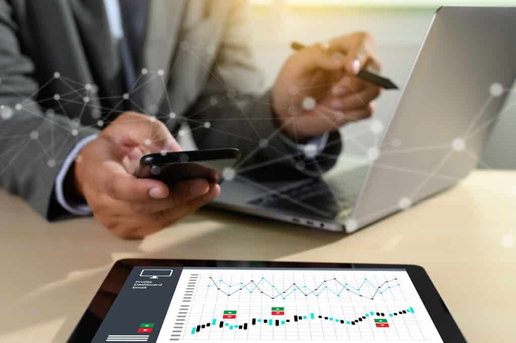 Mężczyzna w garniturze korzysta z tabletu i telefonu komórkowego w agencji marketingowej.