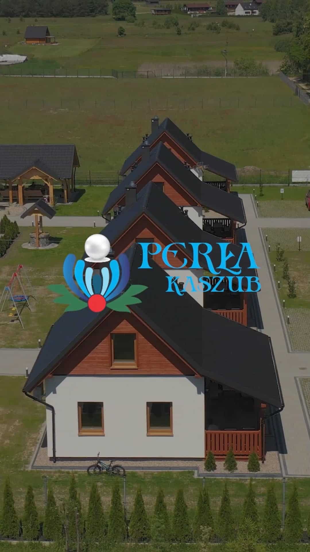 Rząd nowoczesnych, dwupiętrowych domów z czarnymi dachami obok trawnika i placu zabaw. Na obraz nałożone jest logo "Poręa Kaszub".