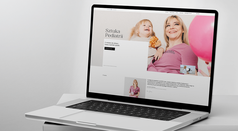 Laptop wyświetla stronę internetową kliniki pediatrycznej przedstawiającą uśmiechniętą kobietę trzymającą dziecko i różowy balon, z tekstem w języku polskim na ekranie.